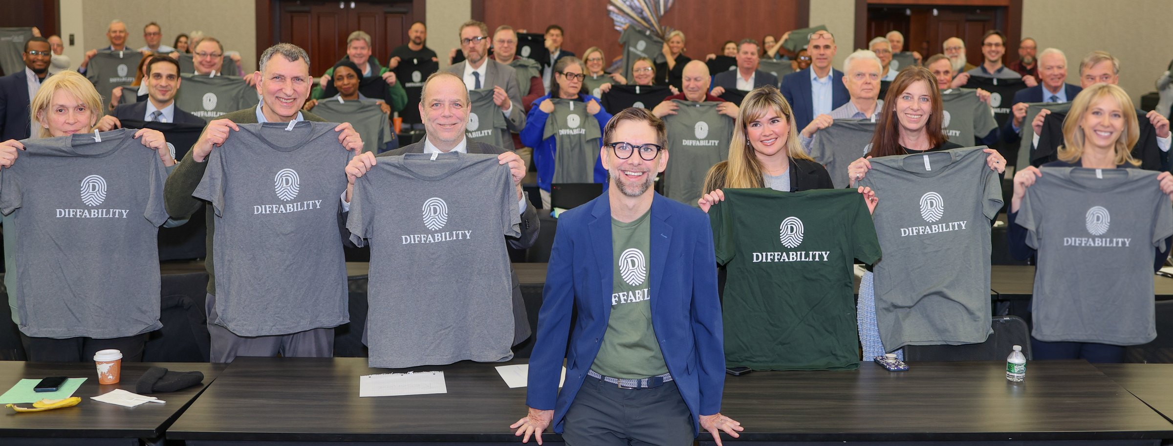 Michael Kutcher with a room of NELA-NJ conference attendees, all holding up Diffability shirts