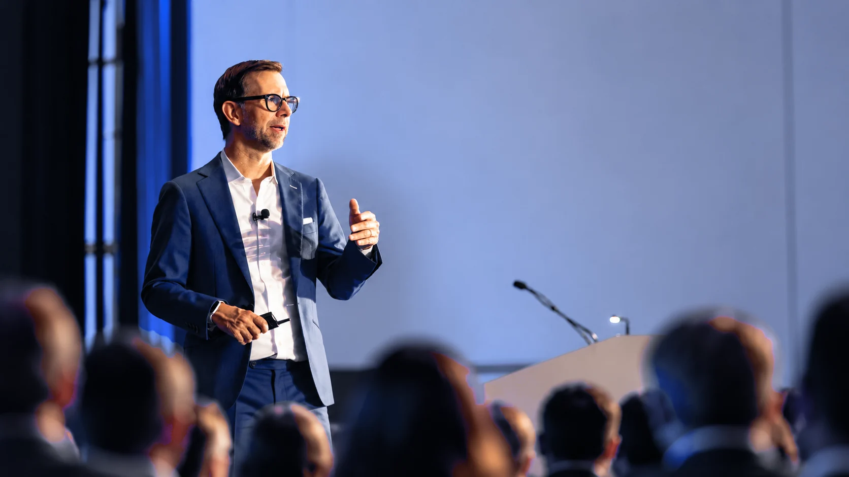 Michael Kutcher mid-keynote, gesturing out to a seated audience