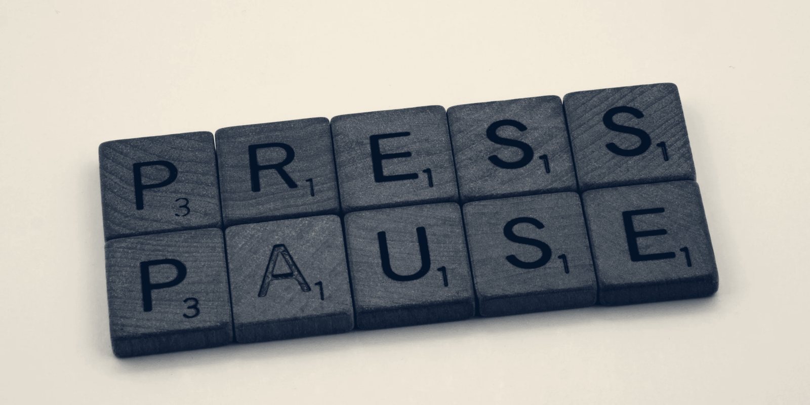 Letter tiles spelling the words Press Pause