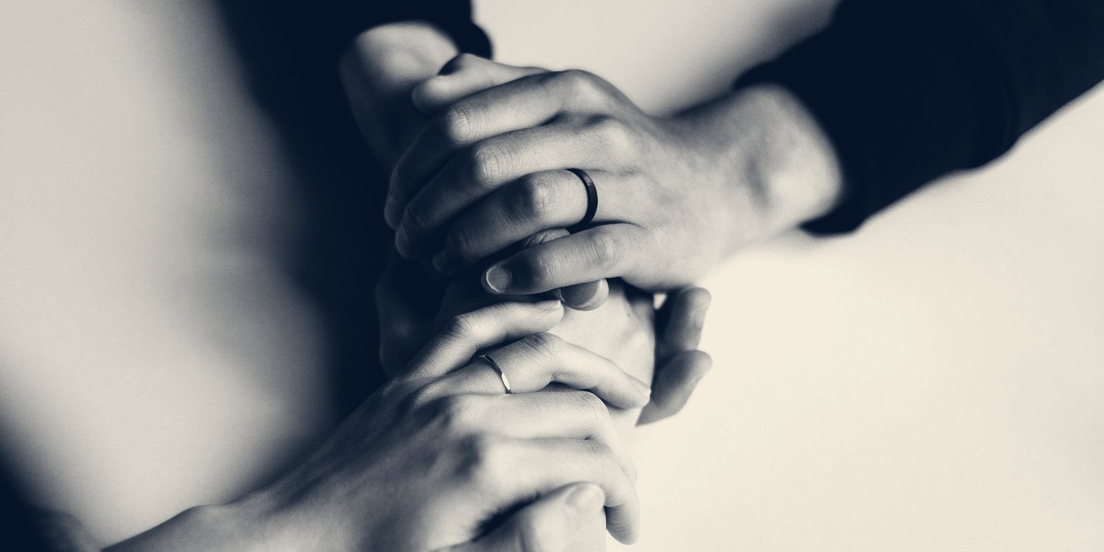 Close-up of two people's hands clasped together