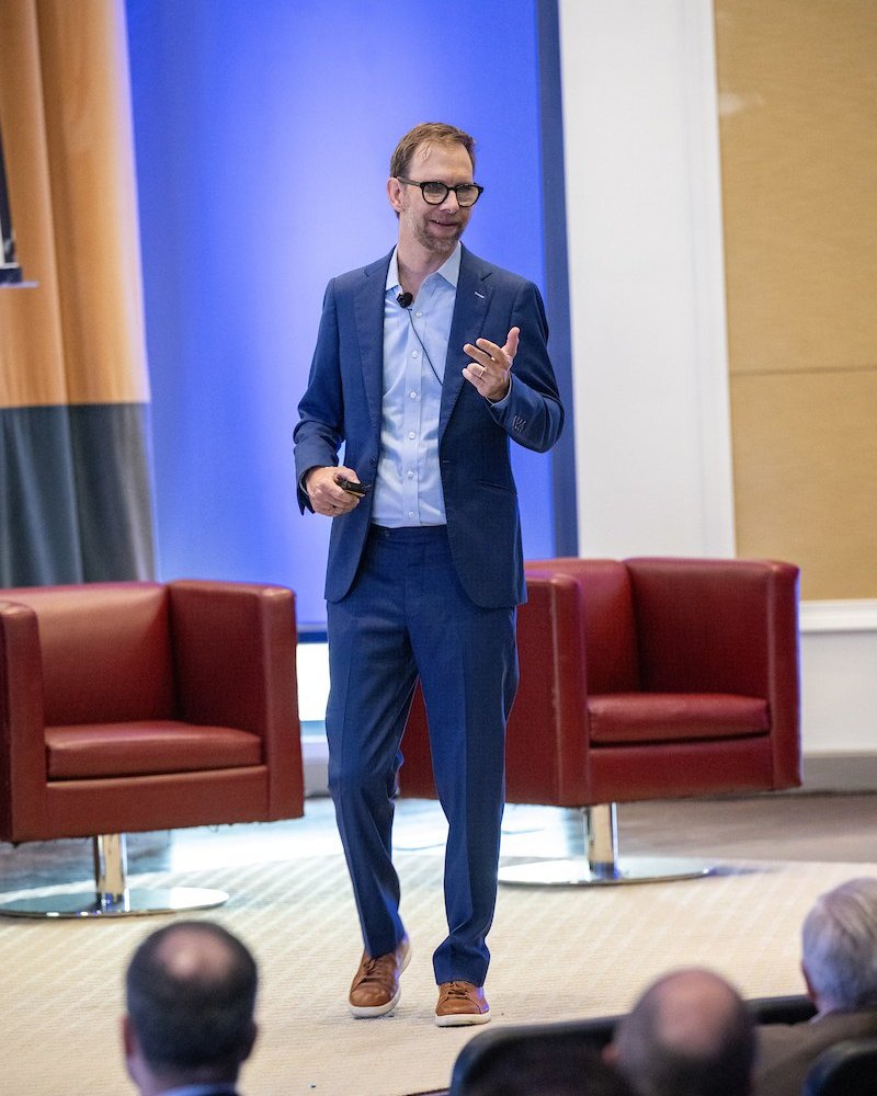 Michael Kutcher in a blue suit on stage at HUB International Thrive